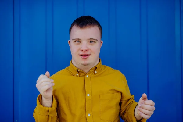 Ein Glücklicher Junger Mann Mit Syndrom Lächelt Vor Blauem Hintergrund — Stockfoto