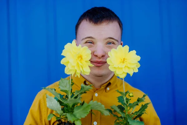 Giovanotto Felice Con Sindrome Che Guarda Macchina Fotografica Tiene Fiori — Foto Stock