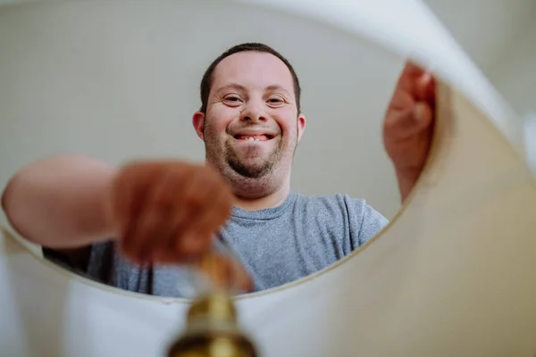 Happy Young Man Syndrome Changing Light Bulb Indoors Home — Stock Photo, Image