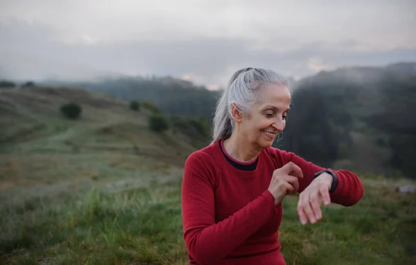 Een Senior Vrouw Jogger Instelling Kijken Naar Sport Smartwatch Het — Stockfoto