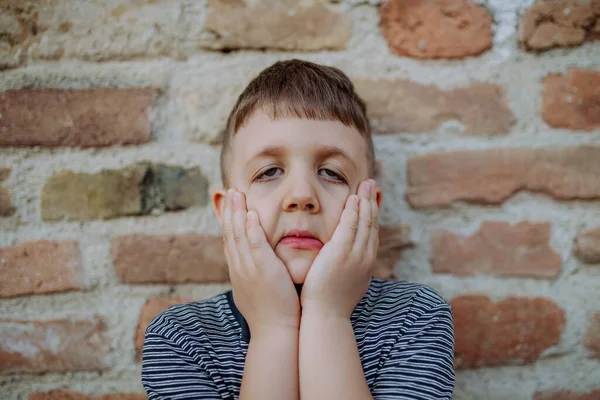 Niño Pequeño Pie Junto Pared Ladrillo Haciendo Caras Graciosas Verano —  Fotos de Stock