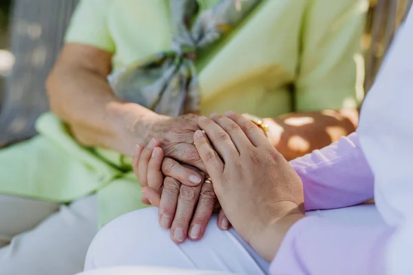 Close Caregiver Consoling Senior Woman Touching Her Hand Sitting Bench — Fotografia de Stock