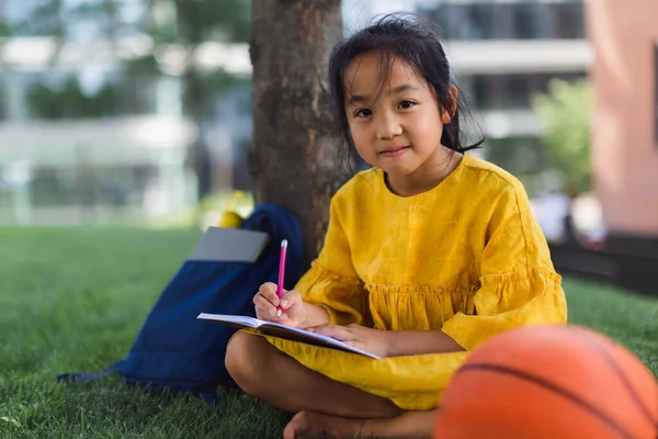 Little Asian Girl Sitting Public Park Writing Some Notes Summer — стоковое фото