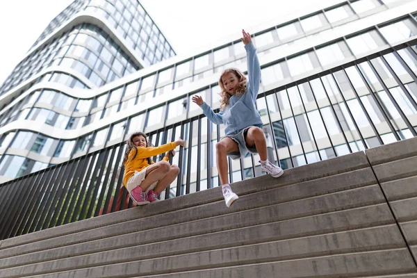 Two Girls Firends Jumping Concrete Wall City Low Angle View — Foto Stock