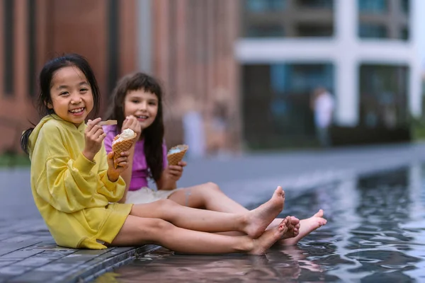 Two Girls Sitting Having Legs Fountain Enjoying Ice Cream Summer —  Fotos de Stock