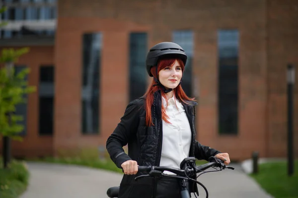 A portrait of businesswoman commuter on the way to work with bike, sustainable lifestyle concept.