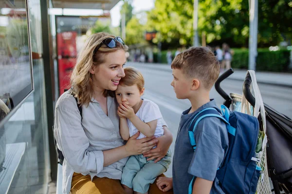 Egy Fiatal Anya Kisgyerekekkel Akik Buszmegállóra Várnak Városban — Stock Fotó