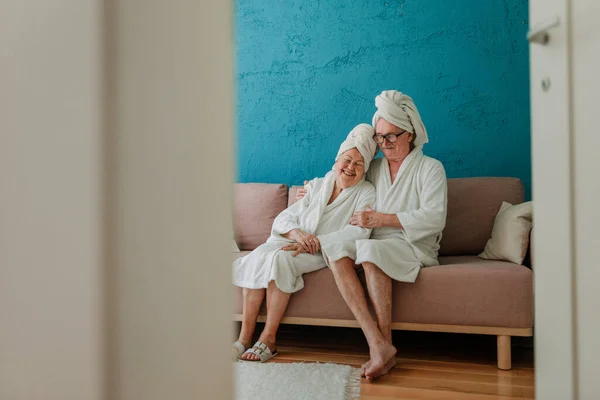 Happy Senior Couple Sitting Together Bathrobe Sofa Having Nice Time — Stock Fotó