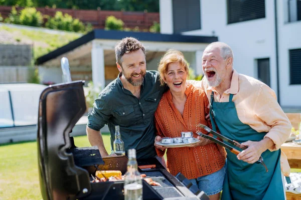 Senior Couple Adult Son Grilling Backyard Summer Family Garden Party — Stockfoto