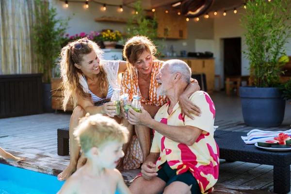Multi Generation Family Enjoying Drinks Sitting Backyard Pool — Stock Fotó