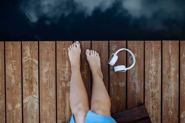 Крупним Планом Жіночі Ноги Навушники Лежать Пірсі Біля Природного Озера — стокове фото