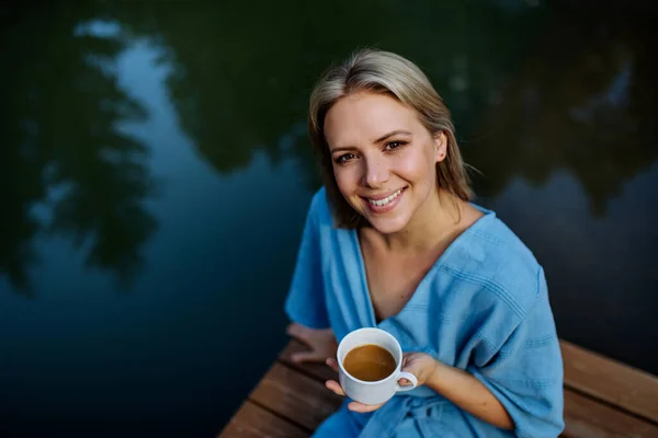Happy Young Woman Sitting Pond Cottege Enjoying Cup Morning Coffee — Foto de Stock