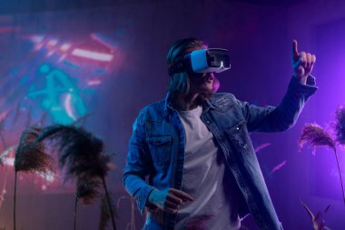 Metaverse digital cyber world technology, a man with virtual reality VR goggles playing augmented reality game, futuristic lifestyle