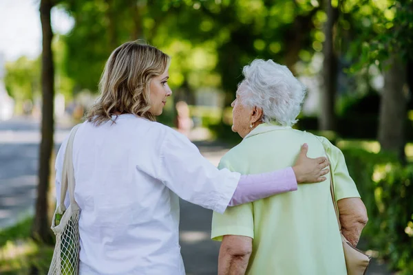 Rear View Caregiver Senior Woman Walk Walker Park Shopping Bag — Stockfoto