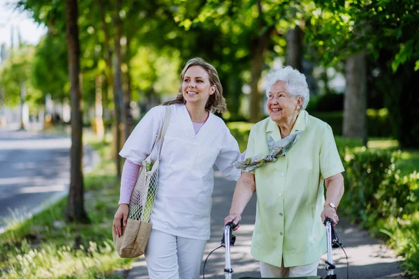 公園を歩く上で高齢女性と介護者の肖像画 — ストック写真