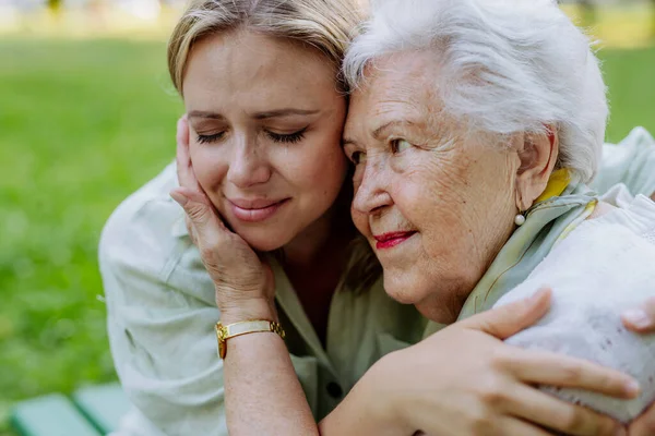 Worried Senior Grandmother Comforting Grown Granddaughter Sitting Bench Park Share — 스톡 사진