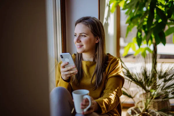 Young College Student Using Phone Sitting Floor Home Enjoying Cup — Stock Fotó