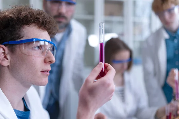 Science students doing a chemical experiment in the laboratory at university.