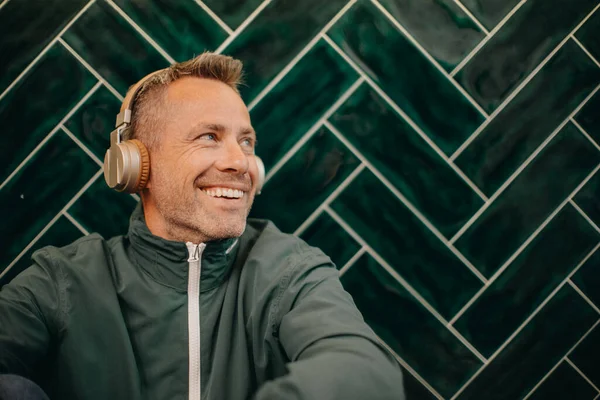 Mature Man Headphones Enjoying Listening Music Indoors Dark Tiled Wall — 图库照片