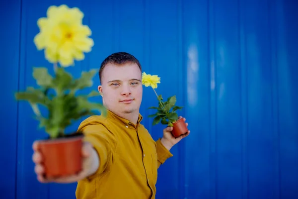 Jovem Feliz Com Síndrome Olhando Para Câmera Segurando Flores Panela — Fotografia de Stock