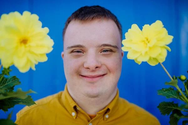 Giovanotto Felice Con Sindrome Che Guarda Macchina Fotografica Tiene Fiori — Foto Stock