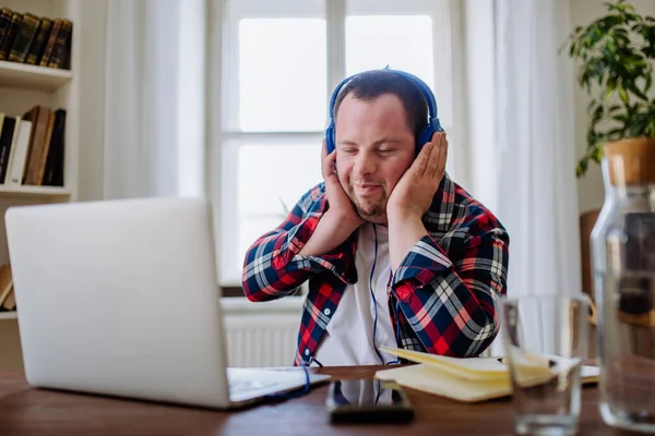 Sendromlu Genç Bir Adam Ofisinde Oturuyor Dizüstü Bilgisayar Kullanıyor Kulaklıklardan — Stok fotoğraf