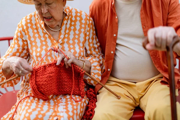Senior Woman Sitting Garden Bench His Husband Knitting Scarf — Stockfoto