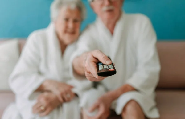 Happy Senior Couple Sitting Sofa Bathrobes Watching — Stock Photo, Image