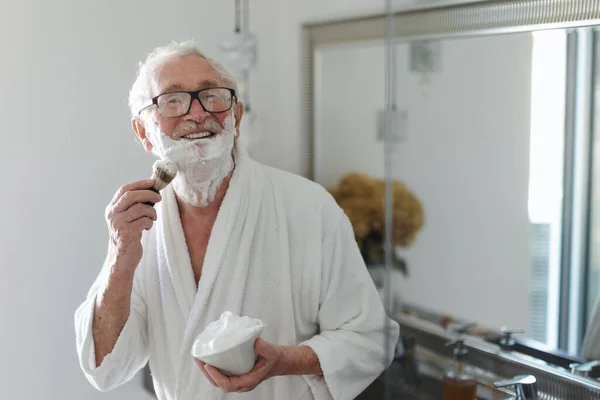 Senior Man Shaving His Beard Bathroom Looking Camera Morning Routine — Fotografia de Stock