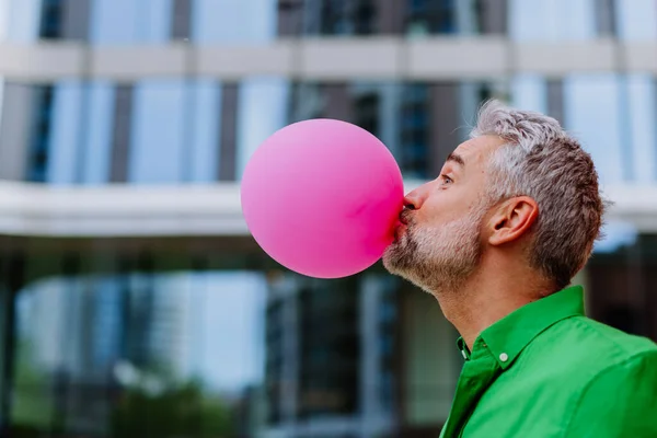 Fun Portrait Happy Energetic Mature Man Inflating Pink Balloon Street — Fotografia de Stock