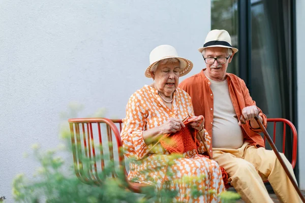 Senior Woman Sitting Garden Bench His Husband Knitting Scarf — Foto Stock