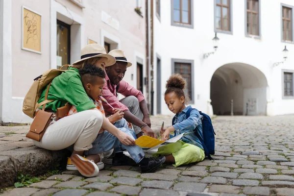 Multiracial Family Travel Together City Centre Sitting Ground Looking Paper — Stockfoto