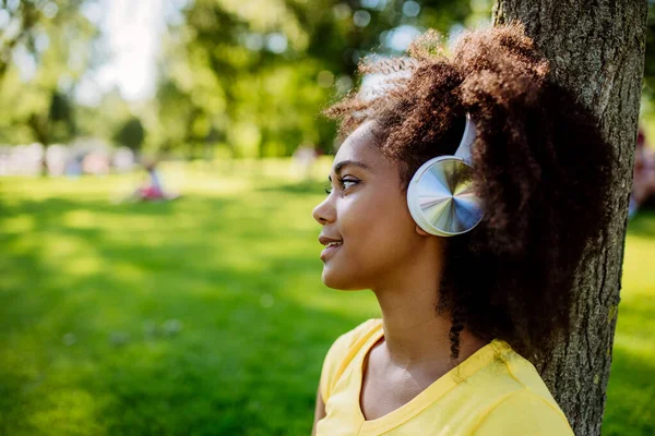 Multiracial Girl Sitting Grass Enjoying Music Headphones Side View — Zdjęcie stockowe