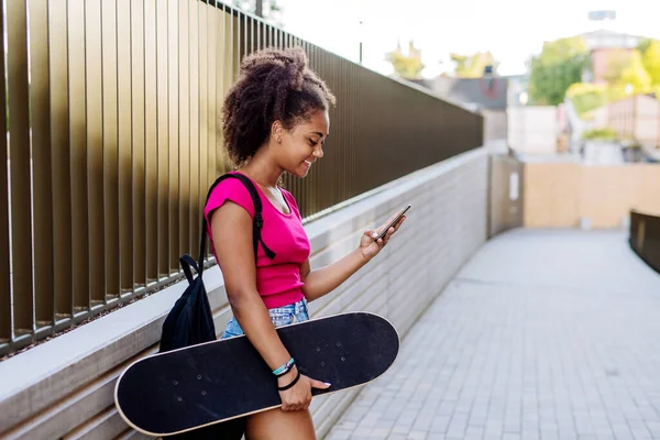 Multiracial Teenage Girl Backpack Skateboard Walking City Summer Day — Zdjęcie stockowe