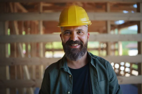 A portrait of construction worker smiling and looking at camera, diy eco-friendly homes concept.