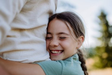 A little girl hugging her father, close up. Fathers day concept.
