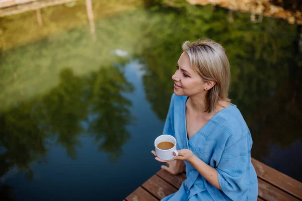 Happy Young Woman Sitting Pond Cottege Enjoying Cup Morning Coffee — Zdjęcie stockowe