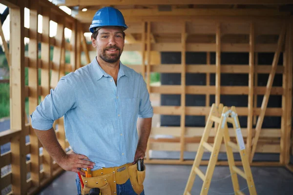 A portrait of construction worker smiling and looking at camera, diy eco-friendly homes concept.