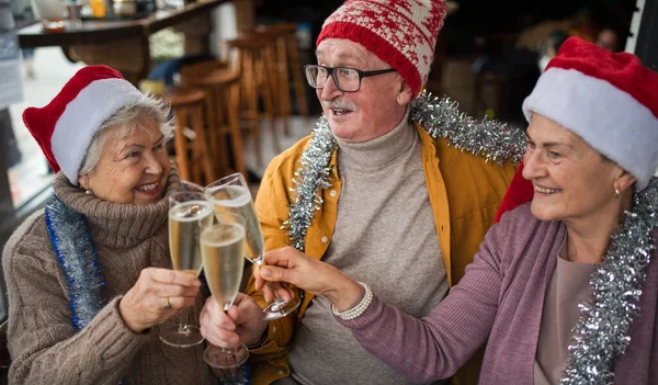 Happy Senior Friends Indoors Cafe Clinking Champagne Glasses Celebrating Christmas — Stockfoto