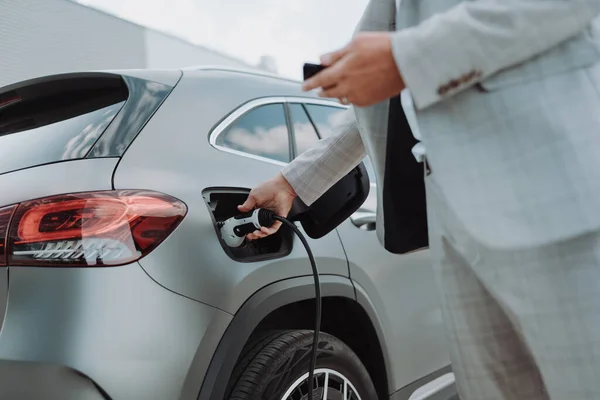 Man Holding Power Supply Cable Electric Vehicle Charging Station Closeup — Fotografia de Stock