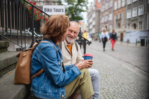 一对快乐的老夫妇坐在楼梯上 在城外喝咖啡 — 图库照片