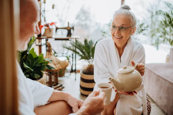 Bornozlu Yaşlı Çift Oturma Odalarında Birlikte Vakit Geçiriyorlar Sıcak Çay — Stok fotoğraf