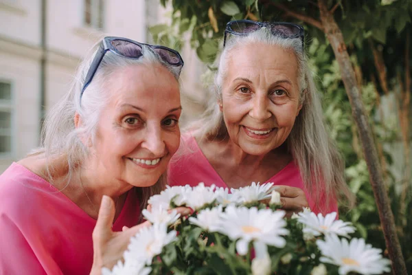 Portrét Seniorských Dvojčat Květinami Venku Městském Parku — Stock fotografie