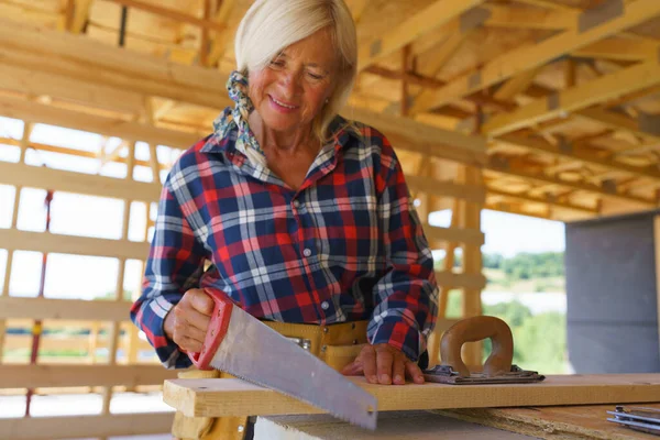 Senior Woman Sawing Her Unfinished Ecological Sustainable Wooden Eco House — Stock Photo, Image