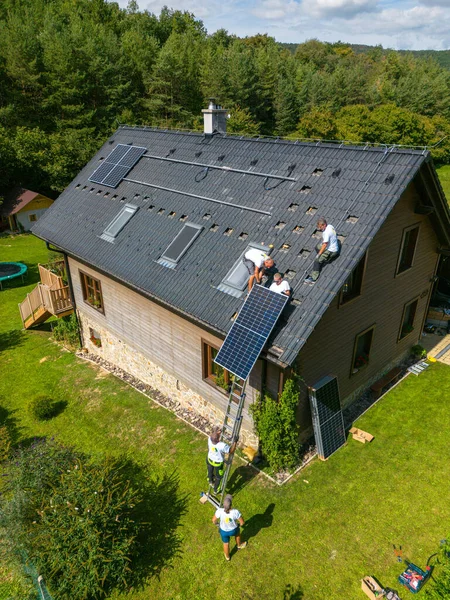 屋根に太陽光発電パネルを設置する男性労働者の高い角度のビュー 代替エネルギー 省資源と持続可能なライフスタイルの概念 — ストック写真