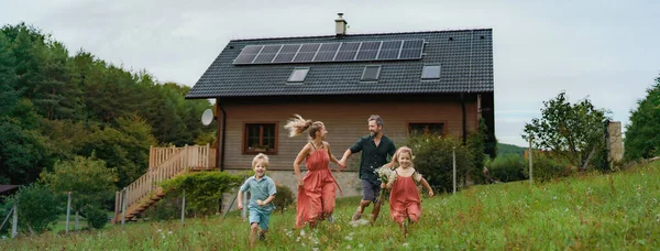 Glückliche Familie Läuft Der Nähe Ihres Hauses Mit Einer Solaranlage — Stockfoto