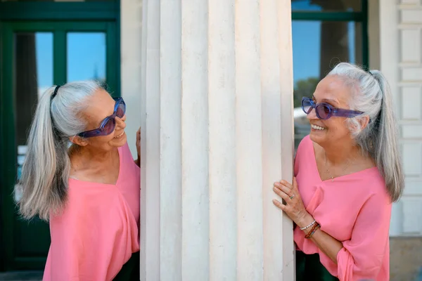 Idős Nők Ikrei Színes Ruhában Egy Városban Építészeti Oszlop Mellett — Stock Fotó