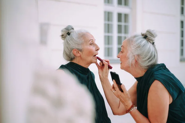 Yaşlı Kadınlar Şehirde Yürüyen Ikizler Makyajlarını Rujla Tamamlıyorlar — Stok fotoğraf