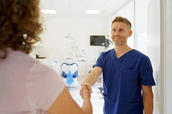 Jonge Tandarts Schudden Handen Met Een Patiënt — Stockfoto