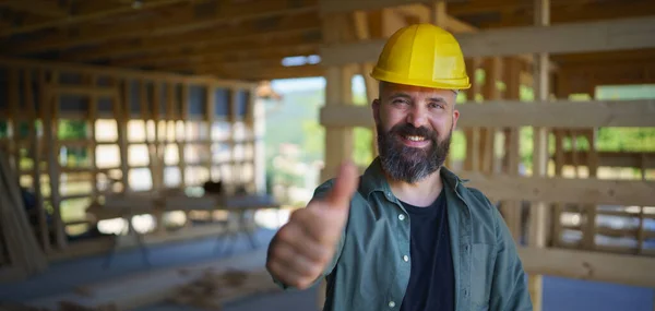 A portrait of construction worker smiling and looking at camera, diy eco-friendly homes concept.